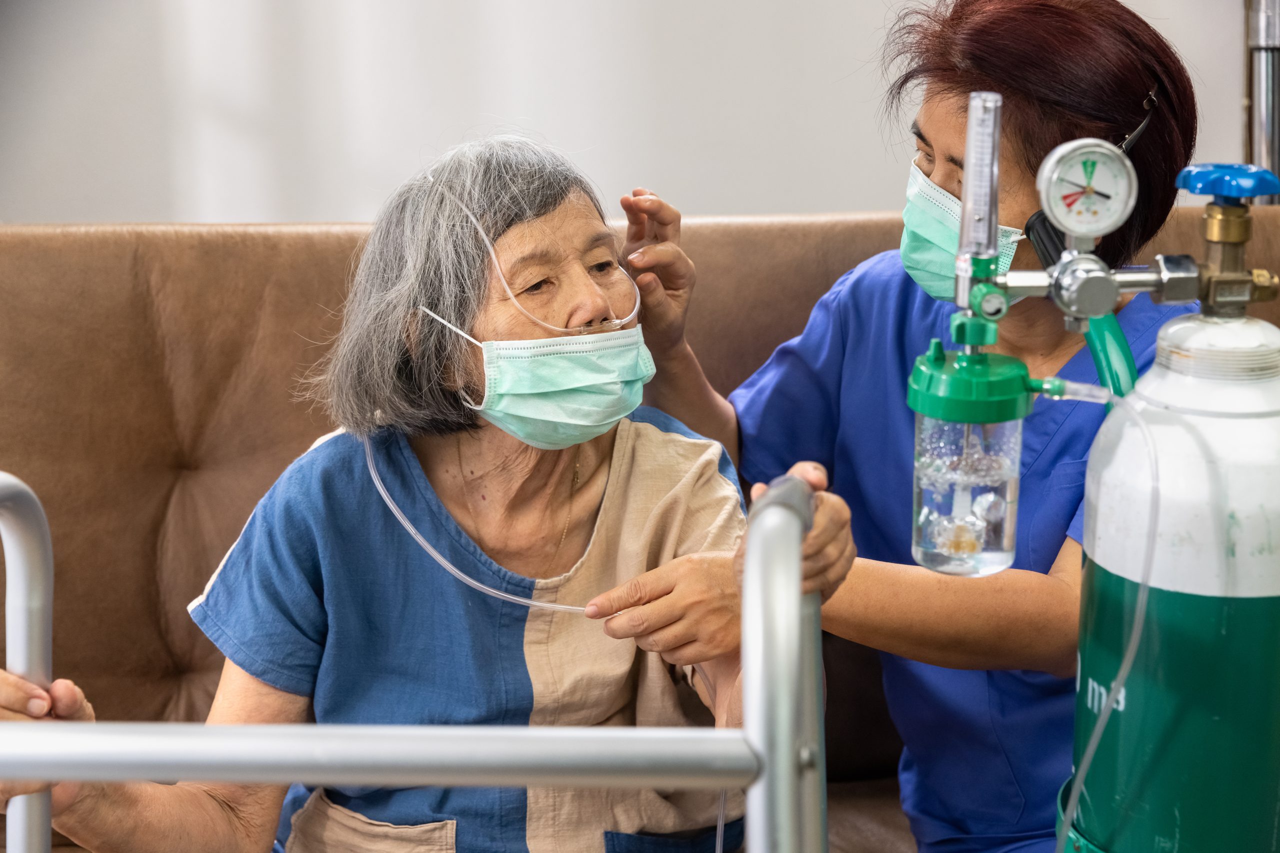 Care team member fitting a nasal cannula for a patient at home